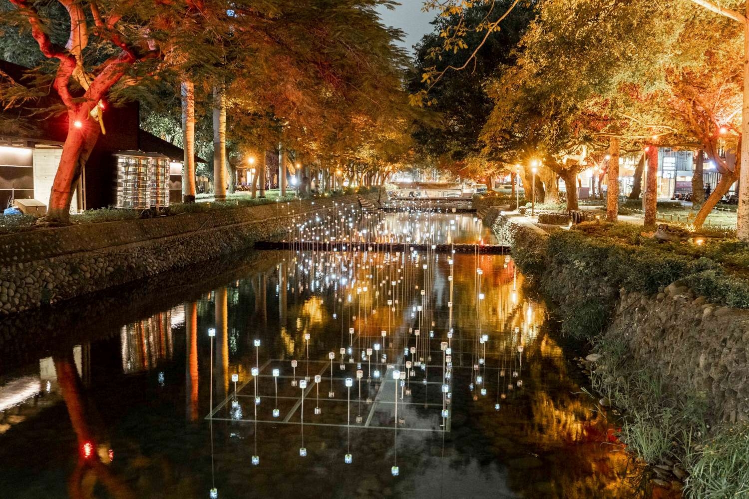 入選阿姆斯特丹燈節的台灣團隊「有用主張」陳冠宏、陳映竹在護城河面上打造「光訊 – 粼河」，宛如許多「螢火蟲」駐足