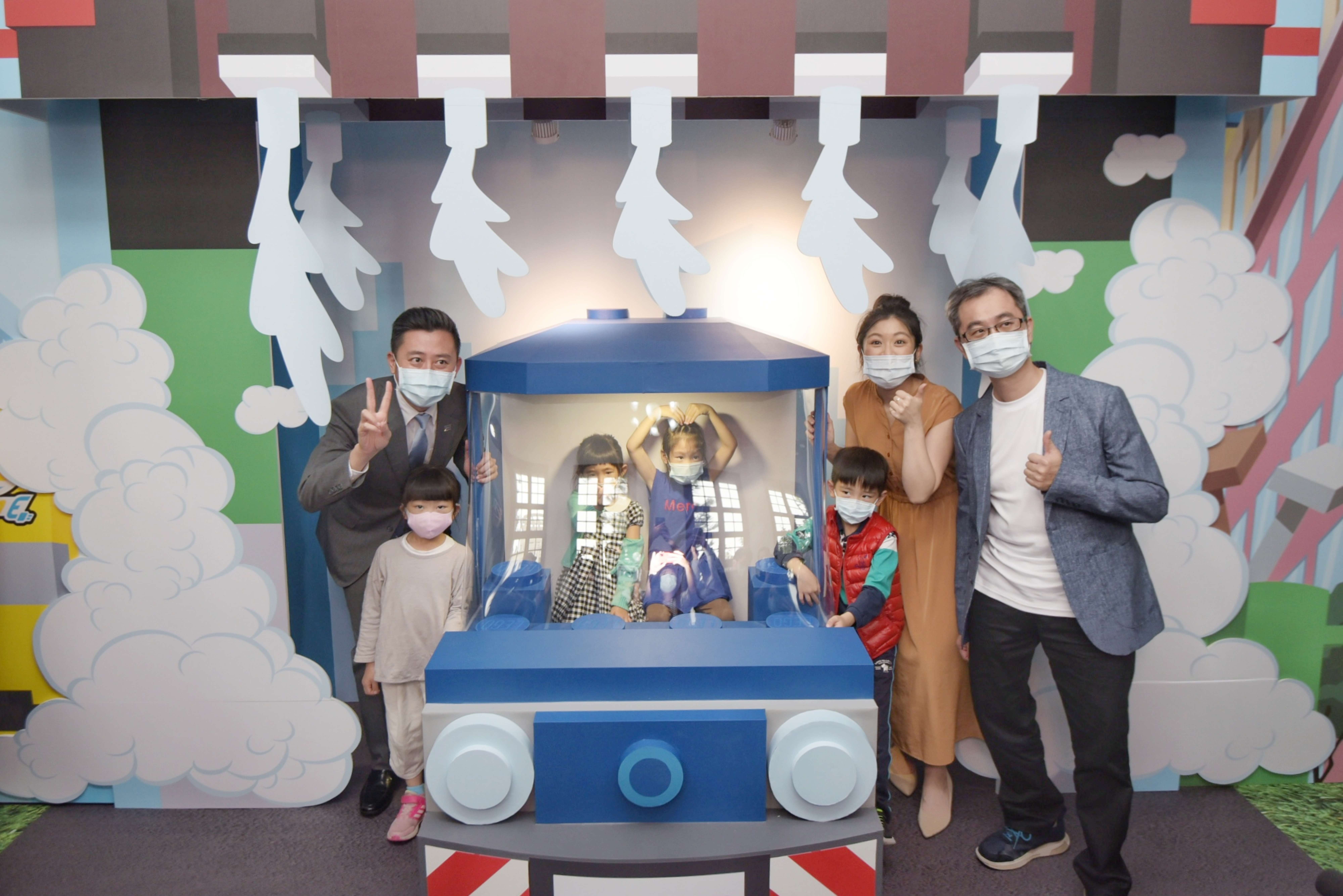 （左起）新竹市長林智堅，樂高品牌副理沈子云，樂高認證大師黃彥智與孩子在樂高火車頭前合影。|