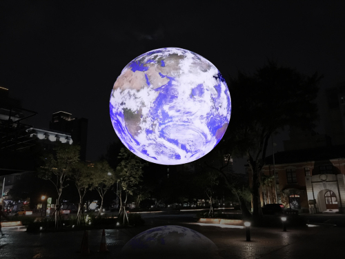 圖三：《蓋亞》為大型地球燈飾垂掛於幸福廣場上空，民眾接近觀賞彷彿太空人由月球俯瞰地球。